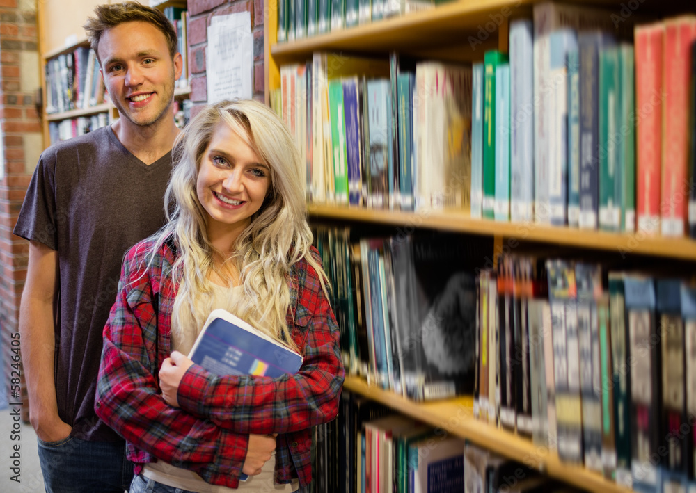 Students standing by bookshelf in the library Students standing by bookshelf in the library