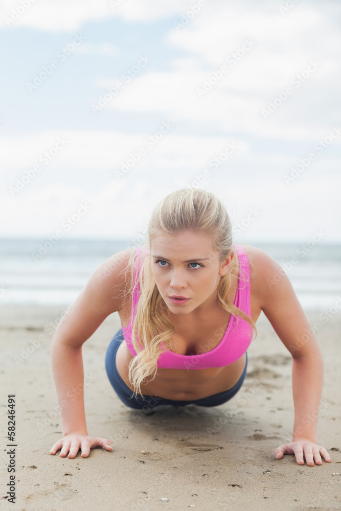 Beautiful woman doing push ups on beach Beautiful woman doing push ups on beach
