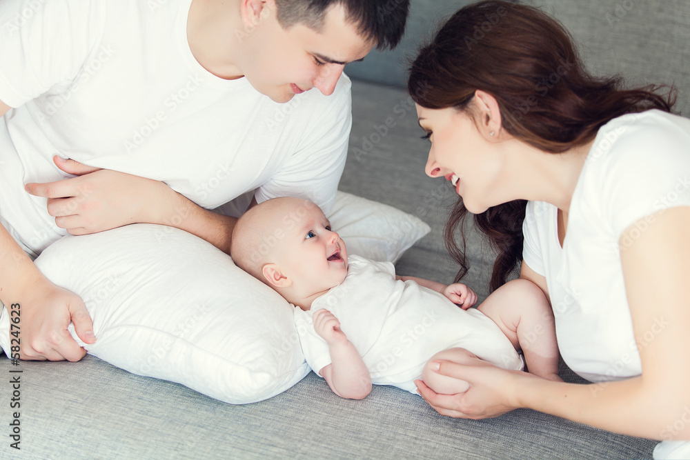 mother and father playing with their cute baby on at home mother and father playing with their cute baby on at home