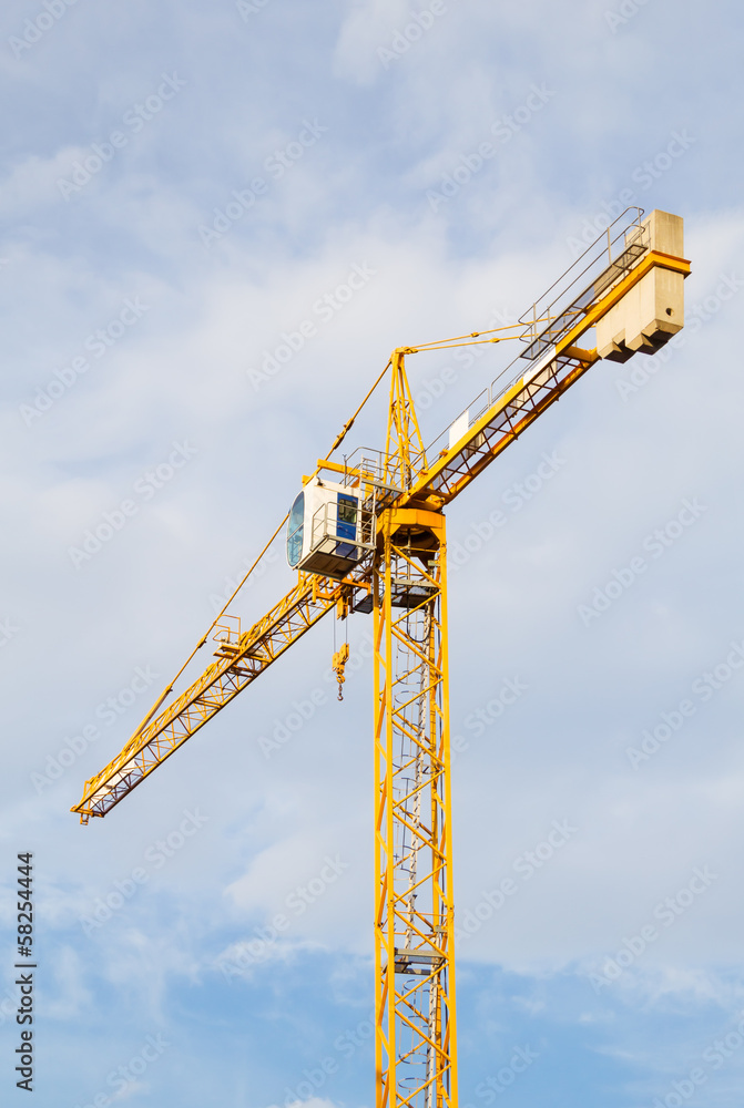 Yellow stationary hoist crane in sunlight. Yellow stationary hoist crane in sunlight.