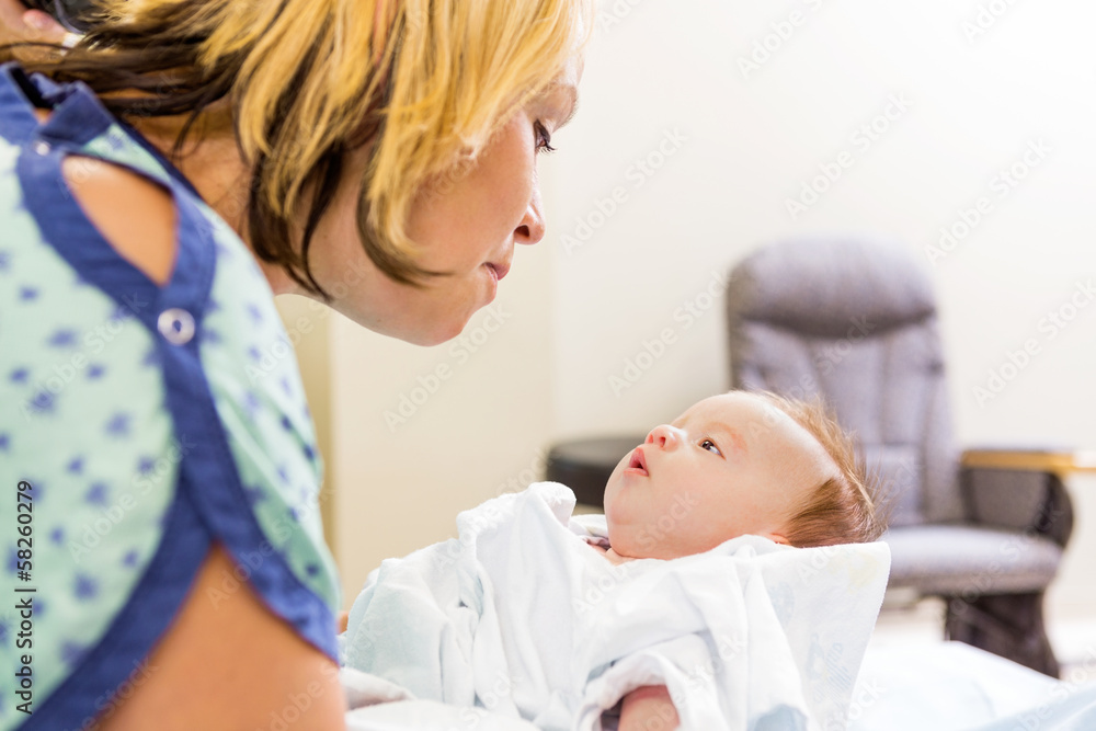 Woman Looking At Cute Newborn Babygirl In Hospital Woman Looking At Cute Newborn Babygirl In Hospital