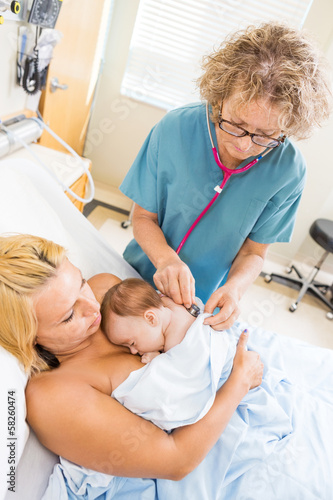 Nurse Examining Babygirl With Stethoscope In Hospital