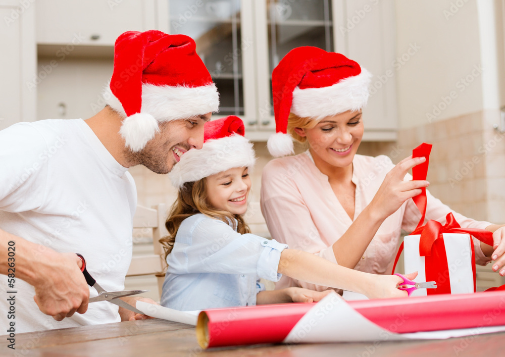 Fototapeta premium smiling family in santa helper hats with gift box