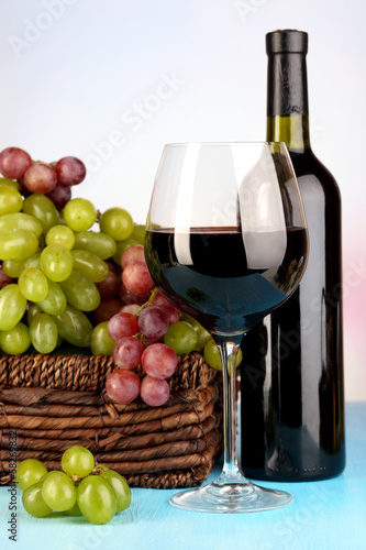 Ripe green and purple grapes in basket with wine