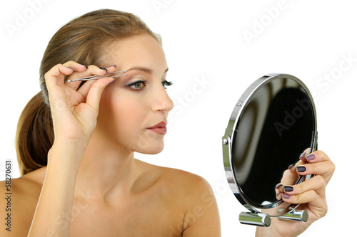 Young woman plucking eyebrows isolated on white photo