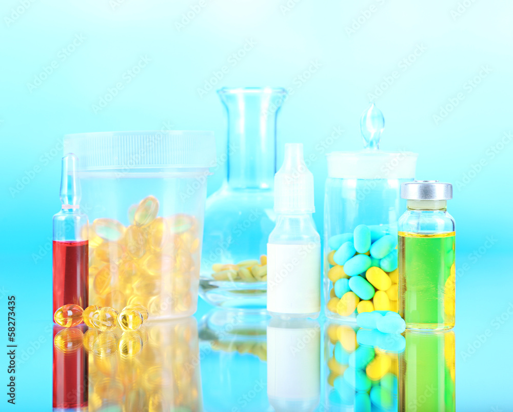 Medical bottles and pills on blue background