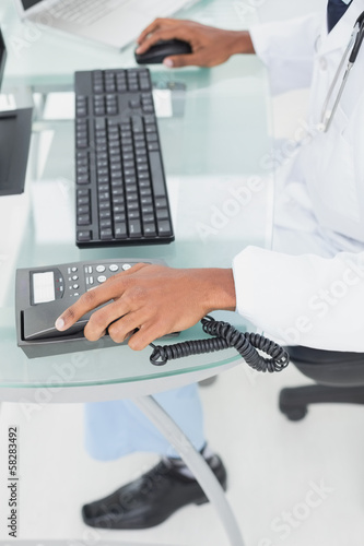 Low section of doctor using computer at medical office