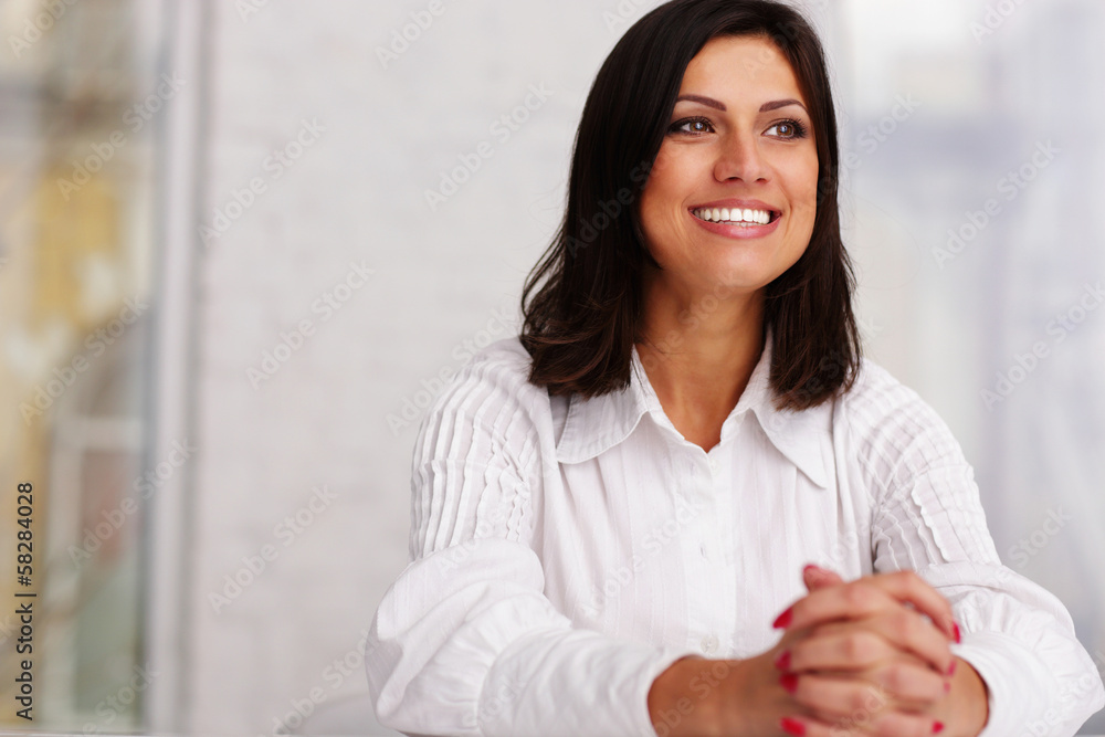 Cheerful confident businesswoman sitting at the table in office