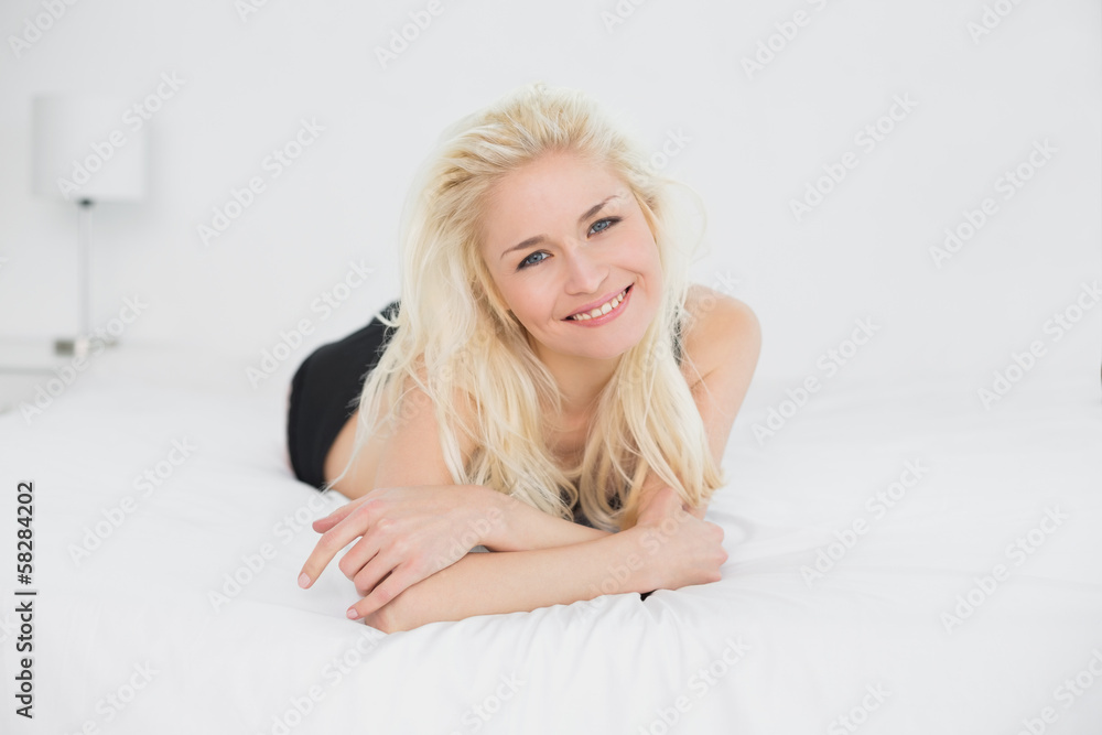 Portrait of a smiling young blond lying in bed Portrait of a smiling young blond lying in bed