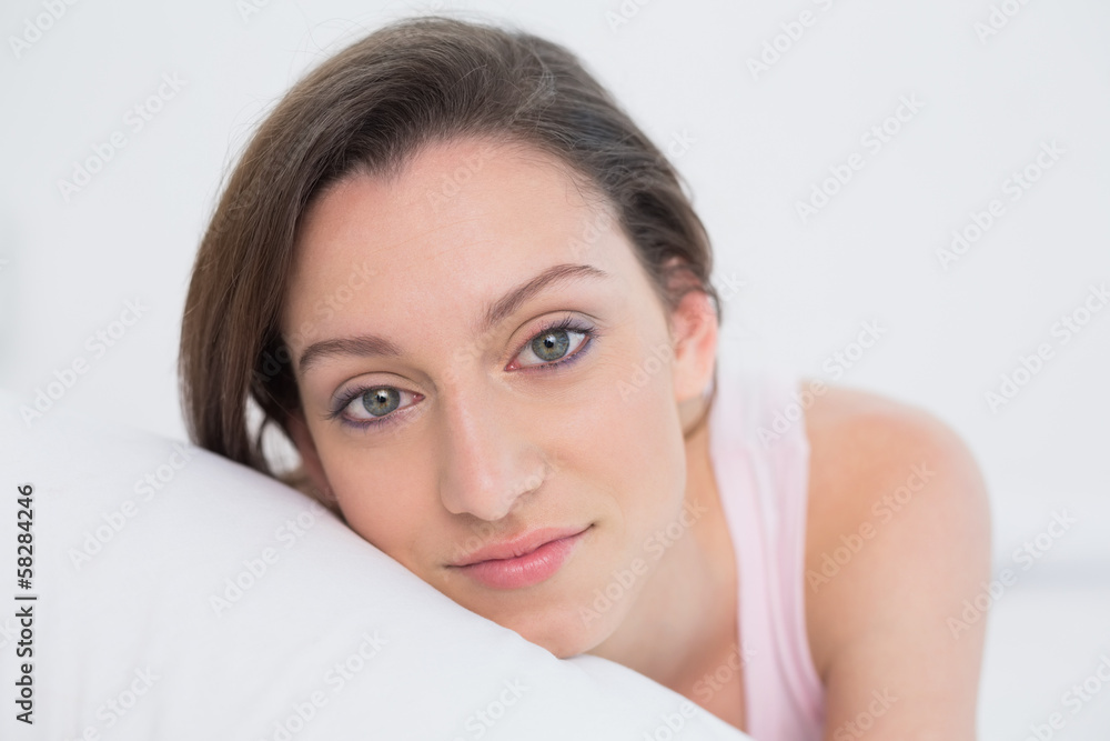 Fototapeta premium Close up portrait of a pretty woman resting in bed