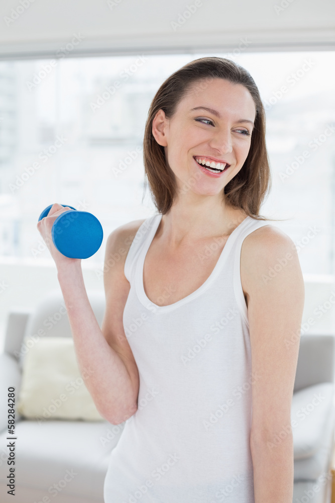 Fit woman exercising with dumbbell in fitness studio Fit woman exercising with dumbbell in fitness studio