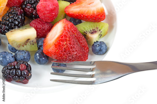 Φωτογραφία Close view of a dish of fresh fruit with a fork
