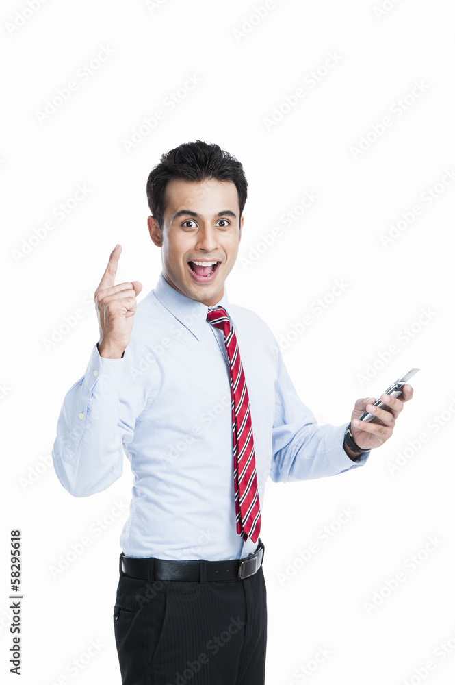 Businessman looking excited while text messaging on a mobile phone Businessman looking excited while text messaging on a mobile phone