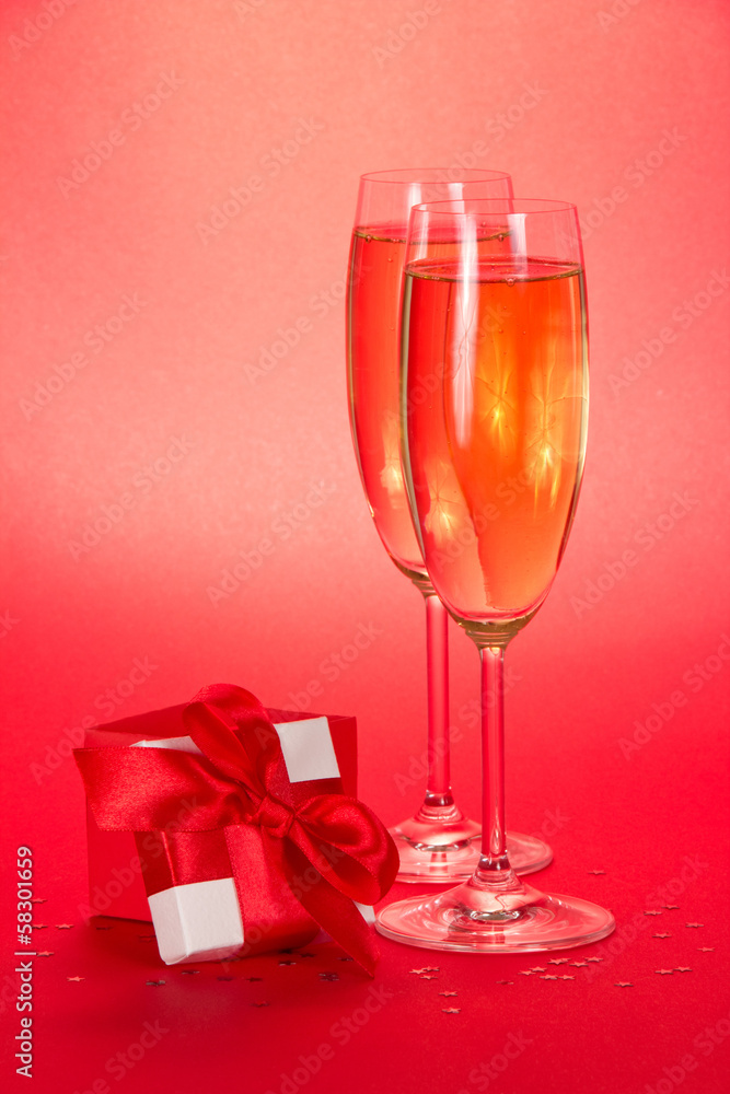 Two glasses with champagne and small gift box Two glasses with champagne and small gift box