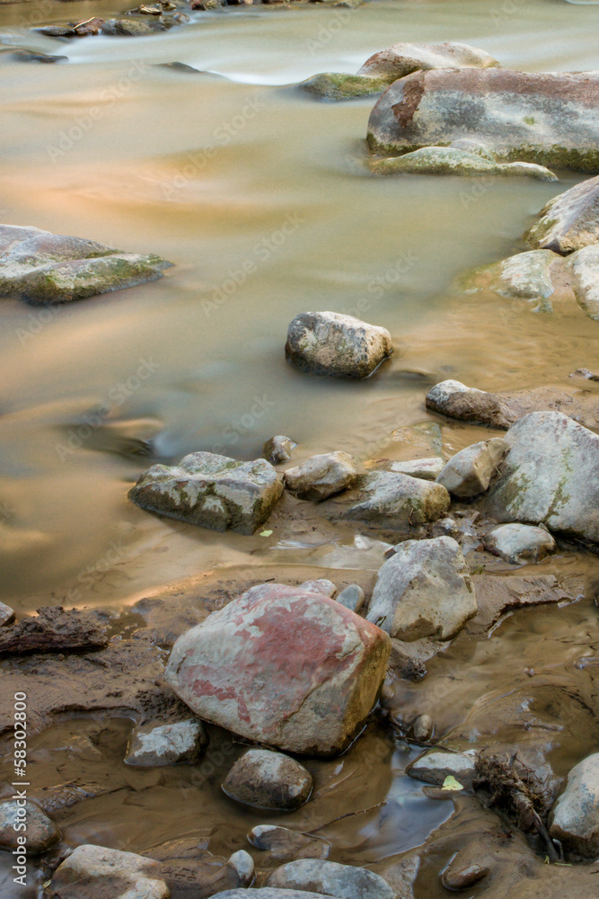 Stream flows through small rocks Stream flows through small rocks