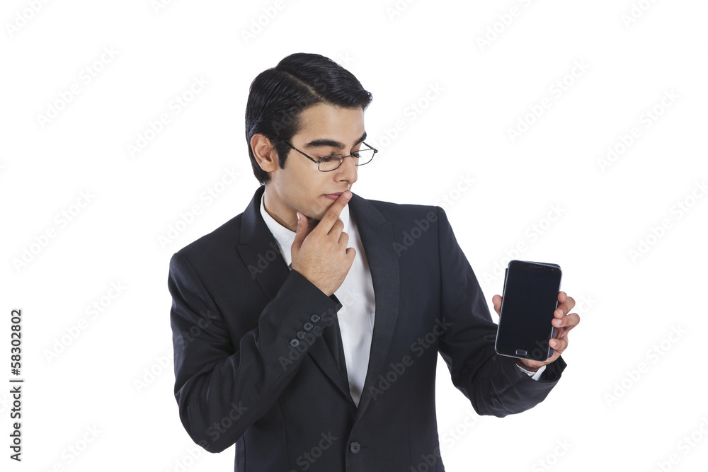 Businessman thinking while showing a mobile phone Businessman thinking while showing a mobile phone
