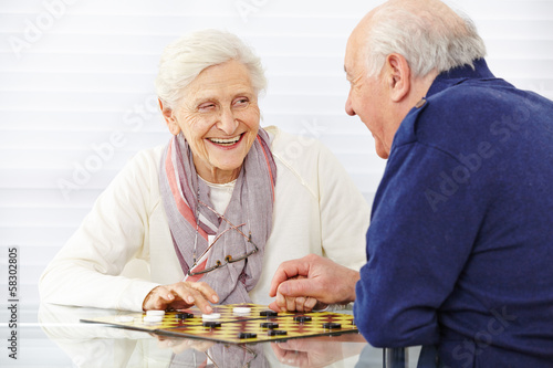 Seniorenpaar spielt Dame im Seniorenheim