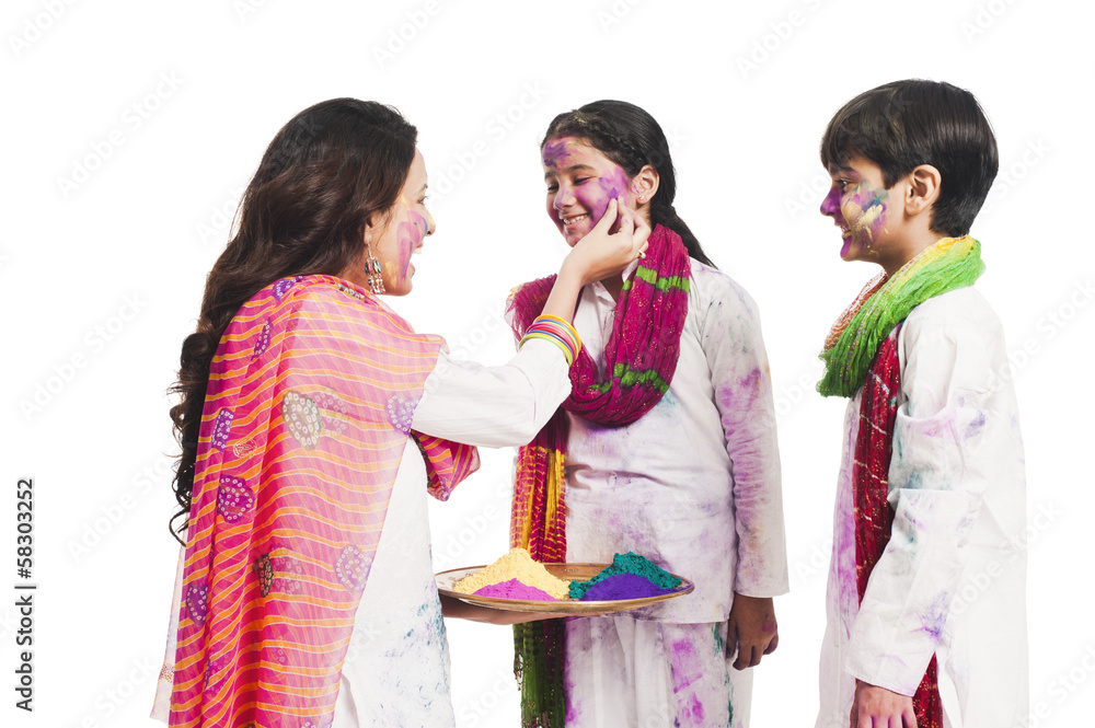 Woman celebrating Holi festival with her children Woman celebrating Holi festival with her children