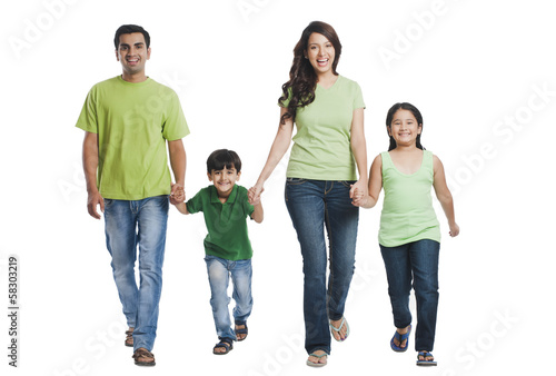 Portrait of a happy family holding hands and walking