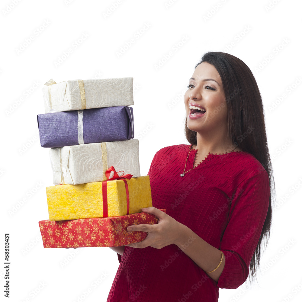 Happy woman holding stack of gifts and smiling Happy woman holding stack of gifts and smiling