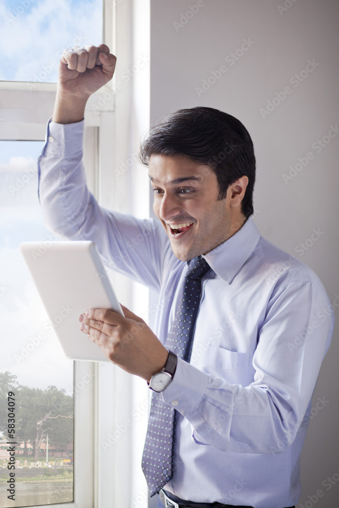 Businessman using a digital tablet and looking excited Businessman using a digital tablet and looking excited