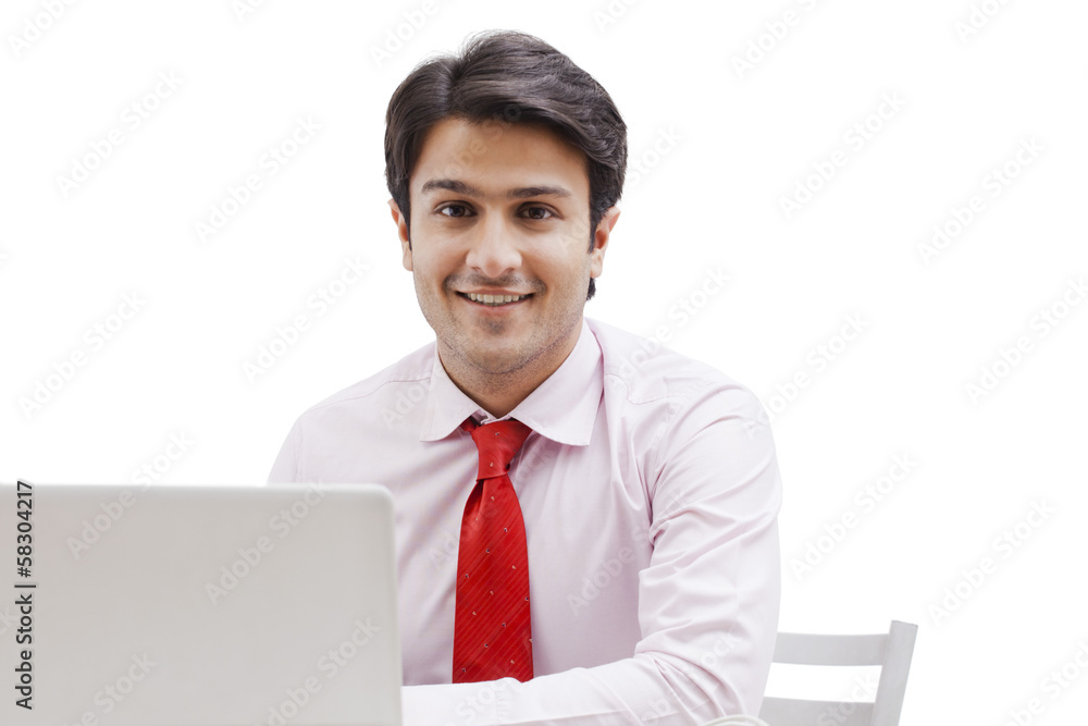 Businessman using a laptop and smiling Businessman using a laptop and smiling