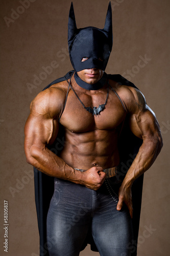 A muscular man in a Batman costume. photo