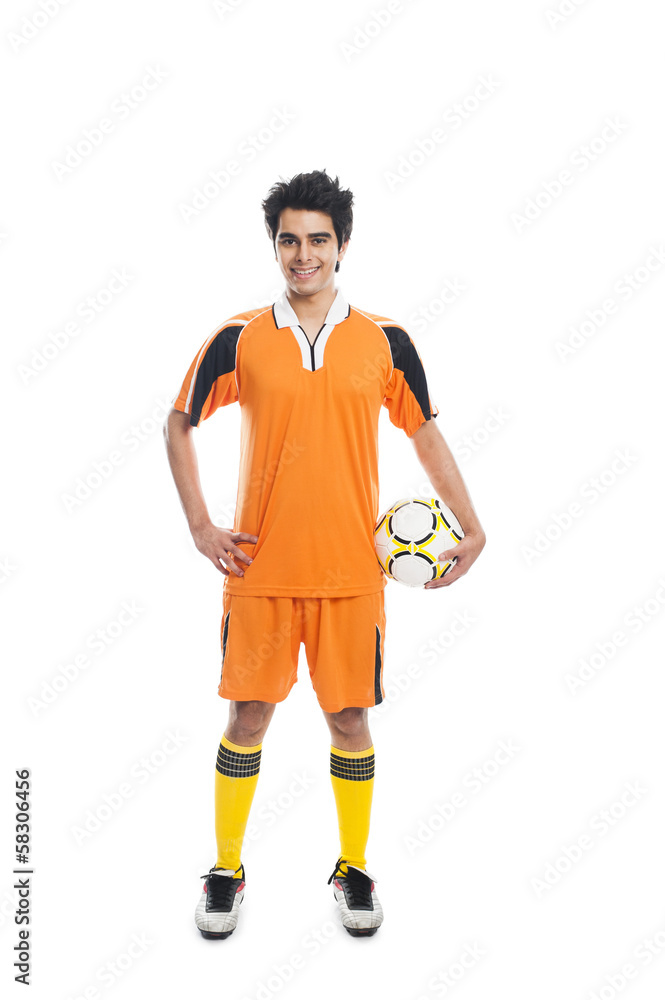 Portrait of a soccer player holding a soccer ball and smiling Portrait of a soccer player holding a soccer ball and smiling