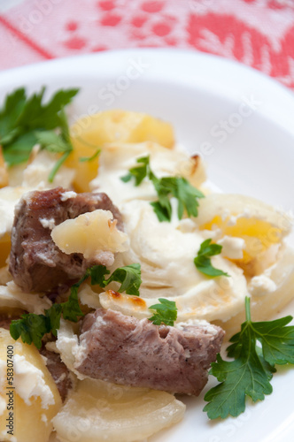 Baked potatoes with meat in a creamy sauce