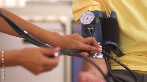 Mexican nurse checking patient's blood pressure