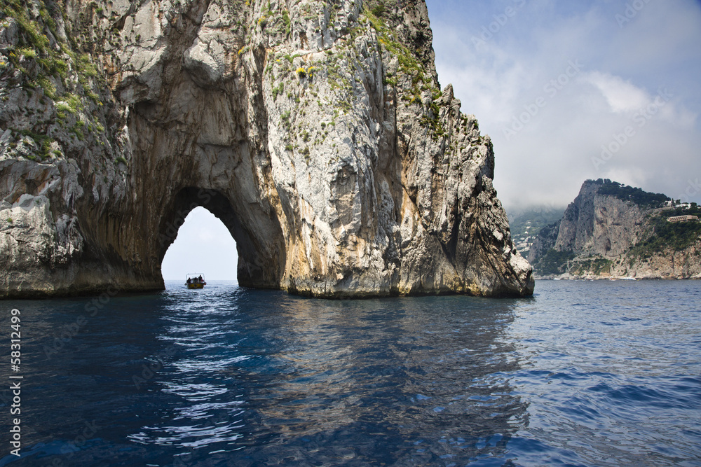 Boat passing through a natural arch, Capri, Naples Province, Campania, Italy