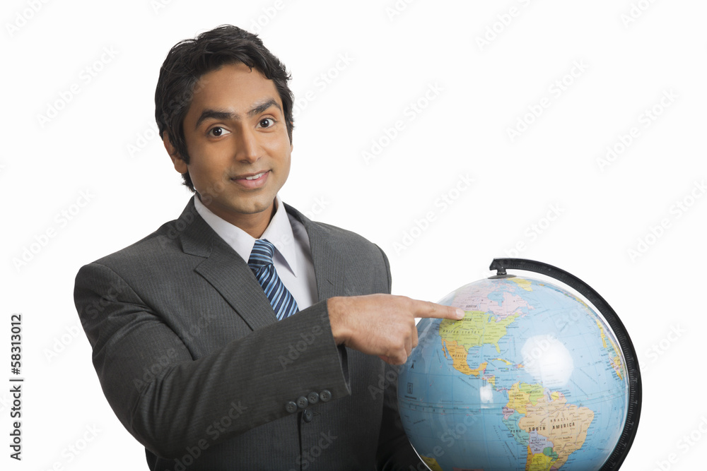 Businessman pointing at a globe Businessman pointing at a globe