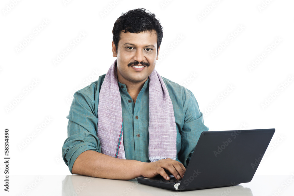 Portrait of a man using a laptop and smiling