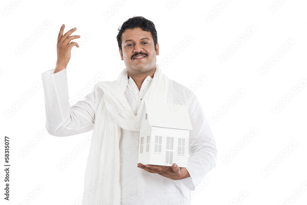 Portrait of a man holding a model home and gesturing