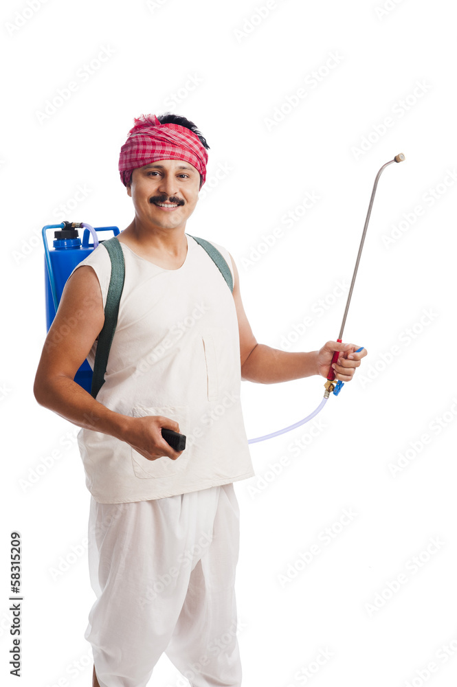 Portrait of a farmer carrying crop sprayer Portrait of a farmer carrying crop sprayer