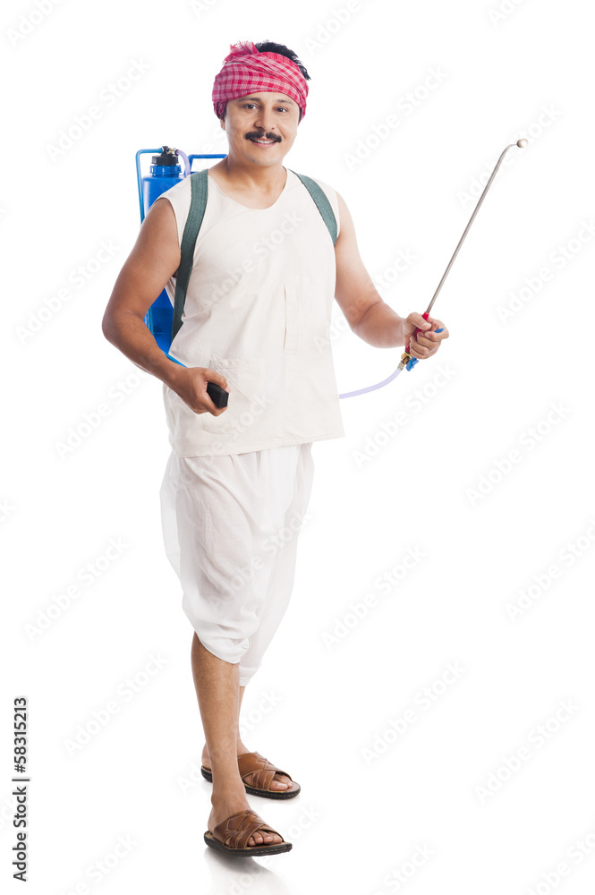 Portrait of a farmer carrying a crop sprayer and smiling Portrait of a farmer carrying a crop sprayer and smiling