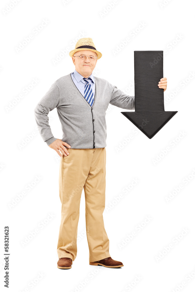 Smiling senior man holding a big black arrow pointing down Smiling senior man holding a big black arrow pointing down