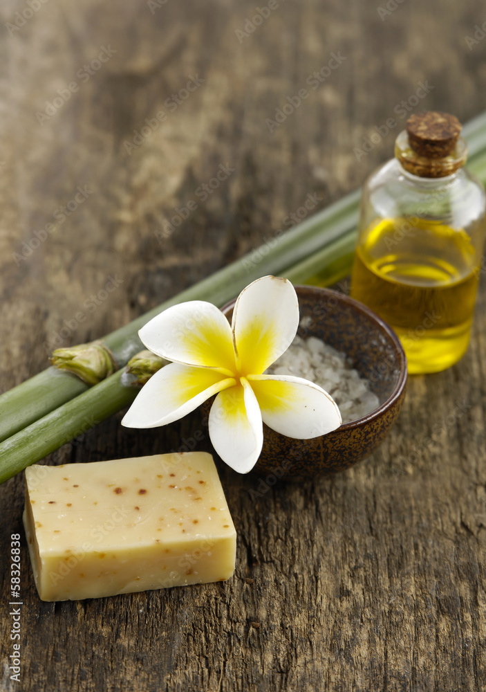 soap, frangipani ,salt in bowl and bamboo grove on old wood