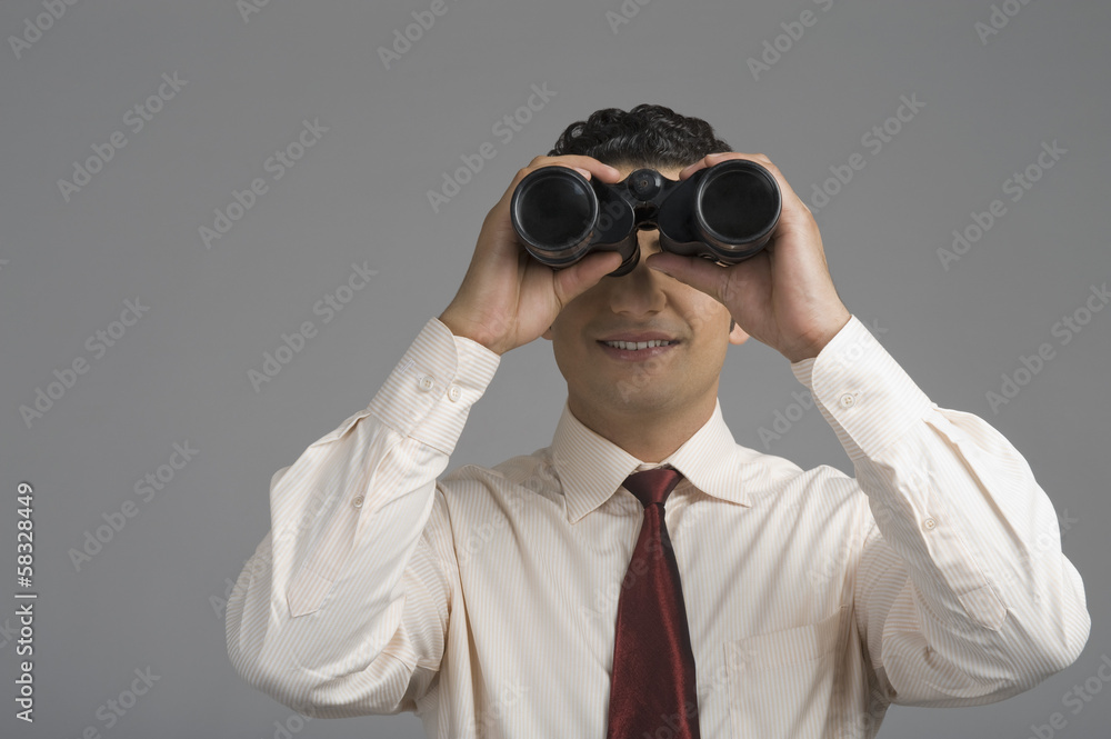 Businessman looking through binoculars Businessman looking through binoculars