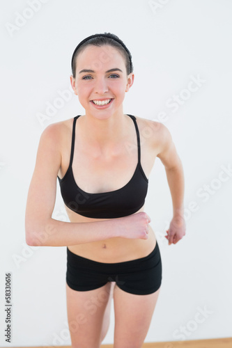 Smiling toned young woman hips in fitness studio