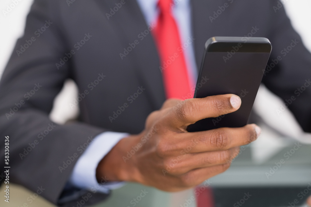 Mid section of well dressed businessman text messaging Mid section of well dressed businessman text messaging