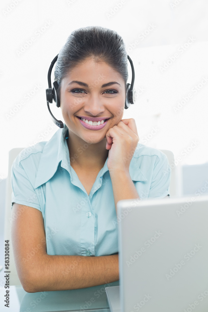 Businesswoman wearing headset in front of laptop Businesswoman wearing headset in front of laptop