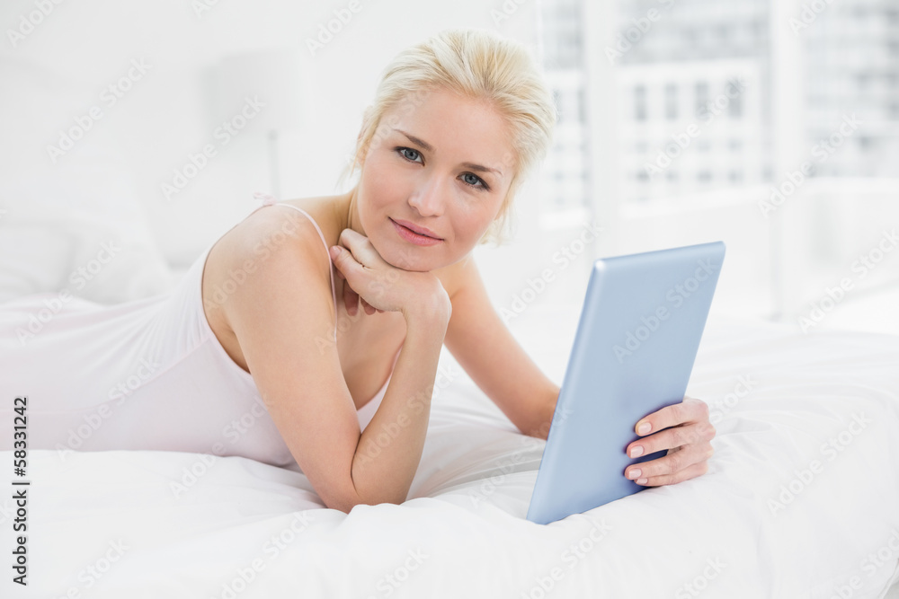 Smiling casual young blond with tablet PC in bed Smiling casual young blond with tablet PC in bed