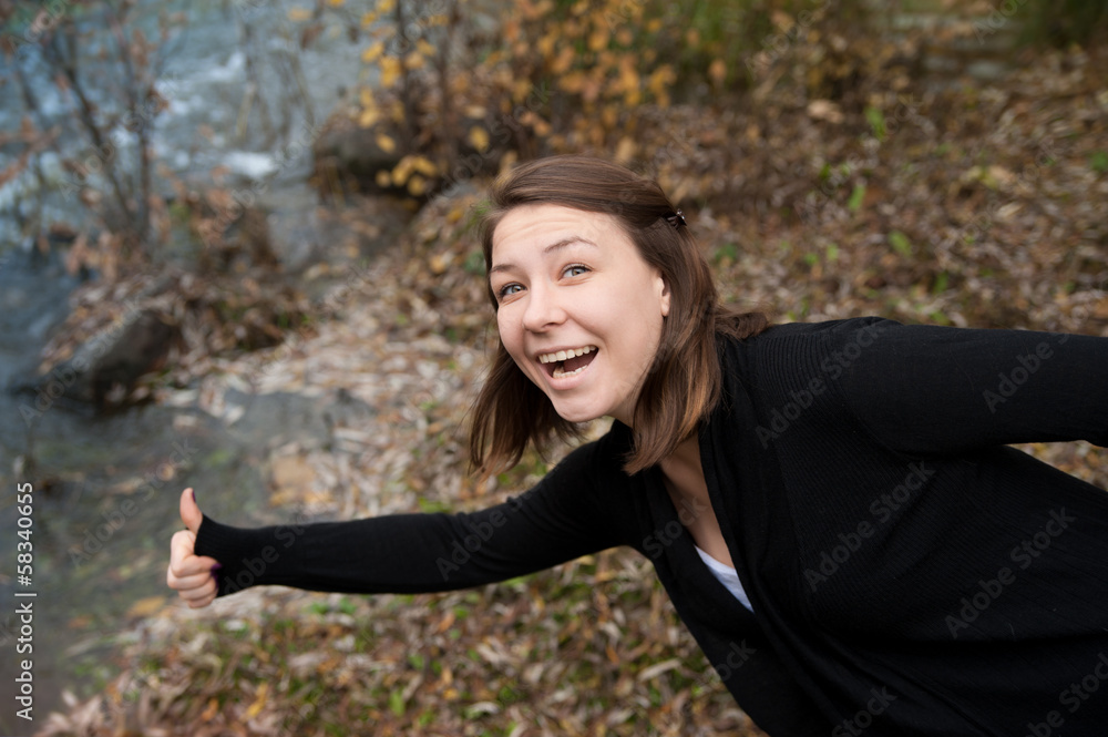 A girl with a raised thumb on the river A girl with a raised thumb on the river