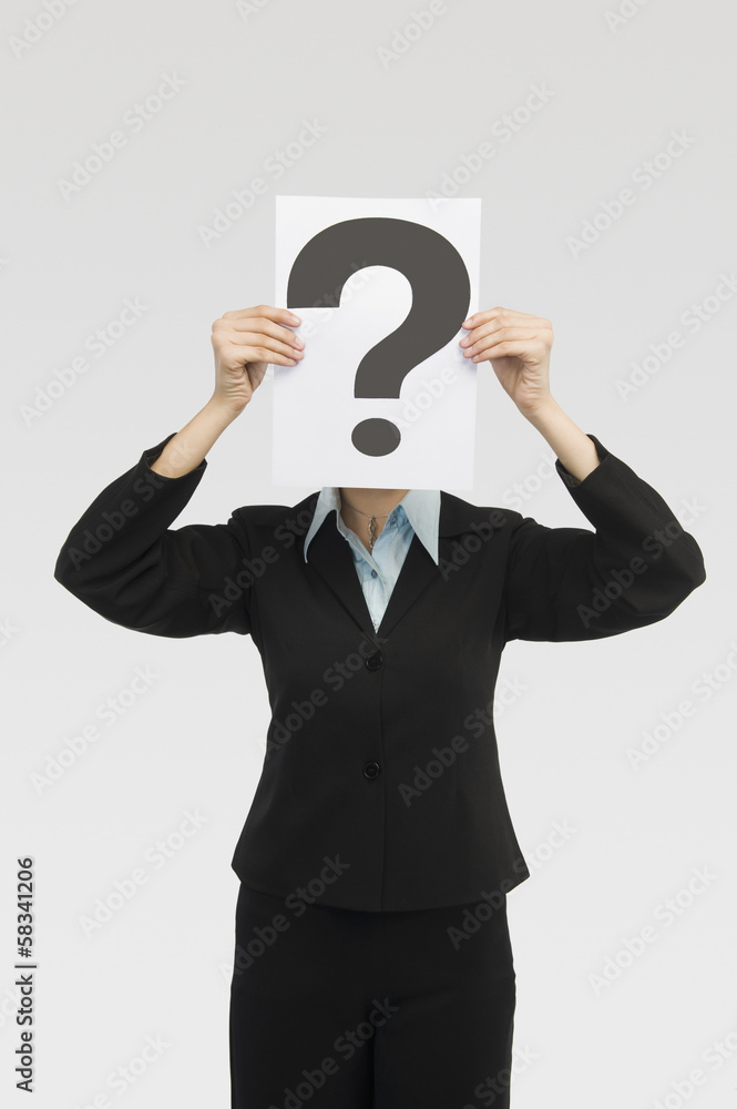 Businesswoman holding a card with question mark in front of a face Businesswoman holding a card with question mark in front of a face