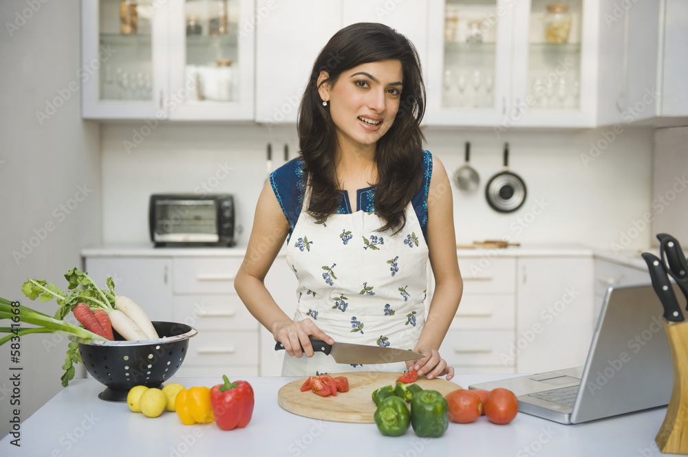 Woman chopping tomatoes in the kitchen Woman chopping tomatoes in the kitchen
