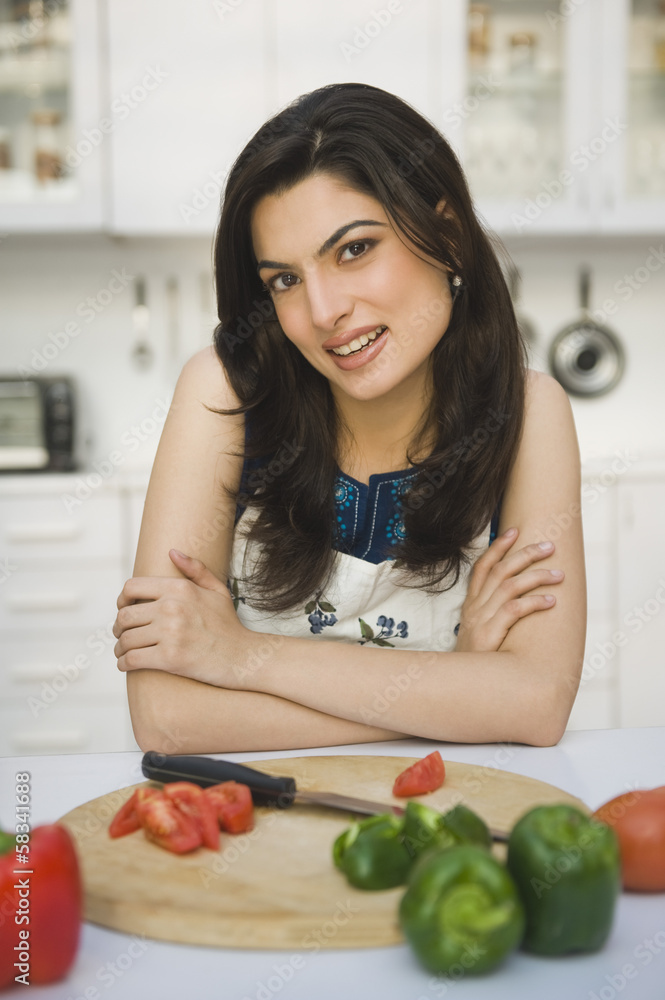 Portrait of a woman leaning on a kitchen counter