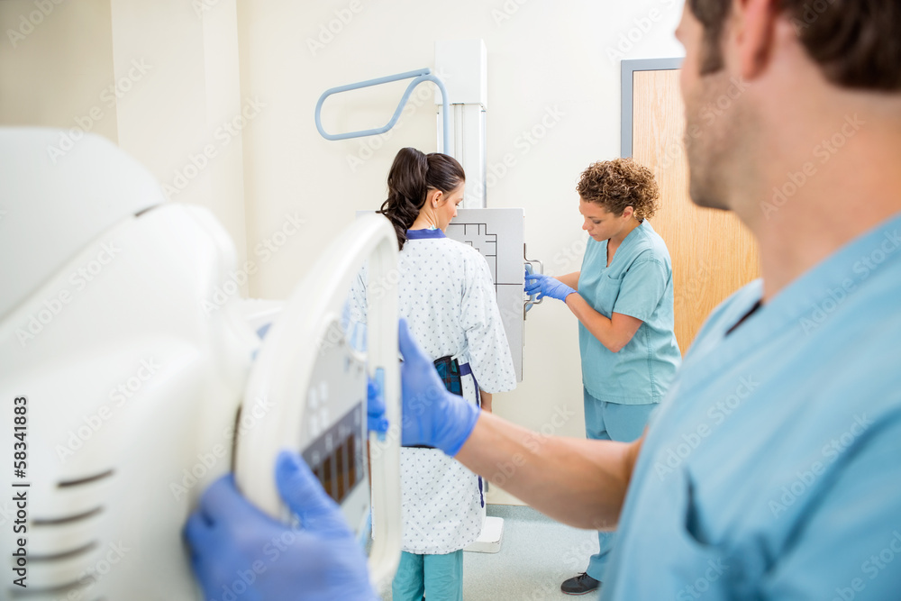 Nurses Adjusting Chest Xray Machines For Patient Nurses Adjusting Chest Xray Machines For Patient