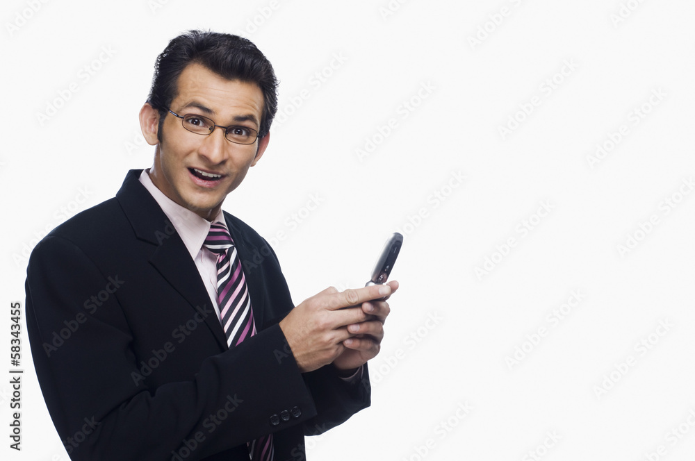 Portrait of a businessman looking surprised while text messaging Portrait of a businessman looking surprised while text messaging