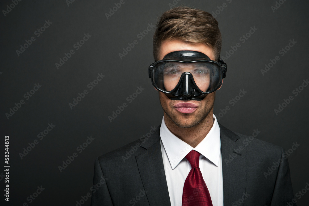 Businessman on a black background wearing a snorkel and mask